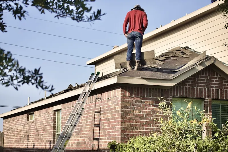 Professional roofer working on a residential roof in Port Jefferson Station